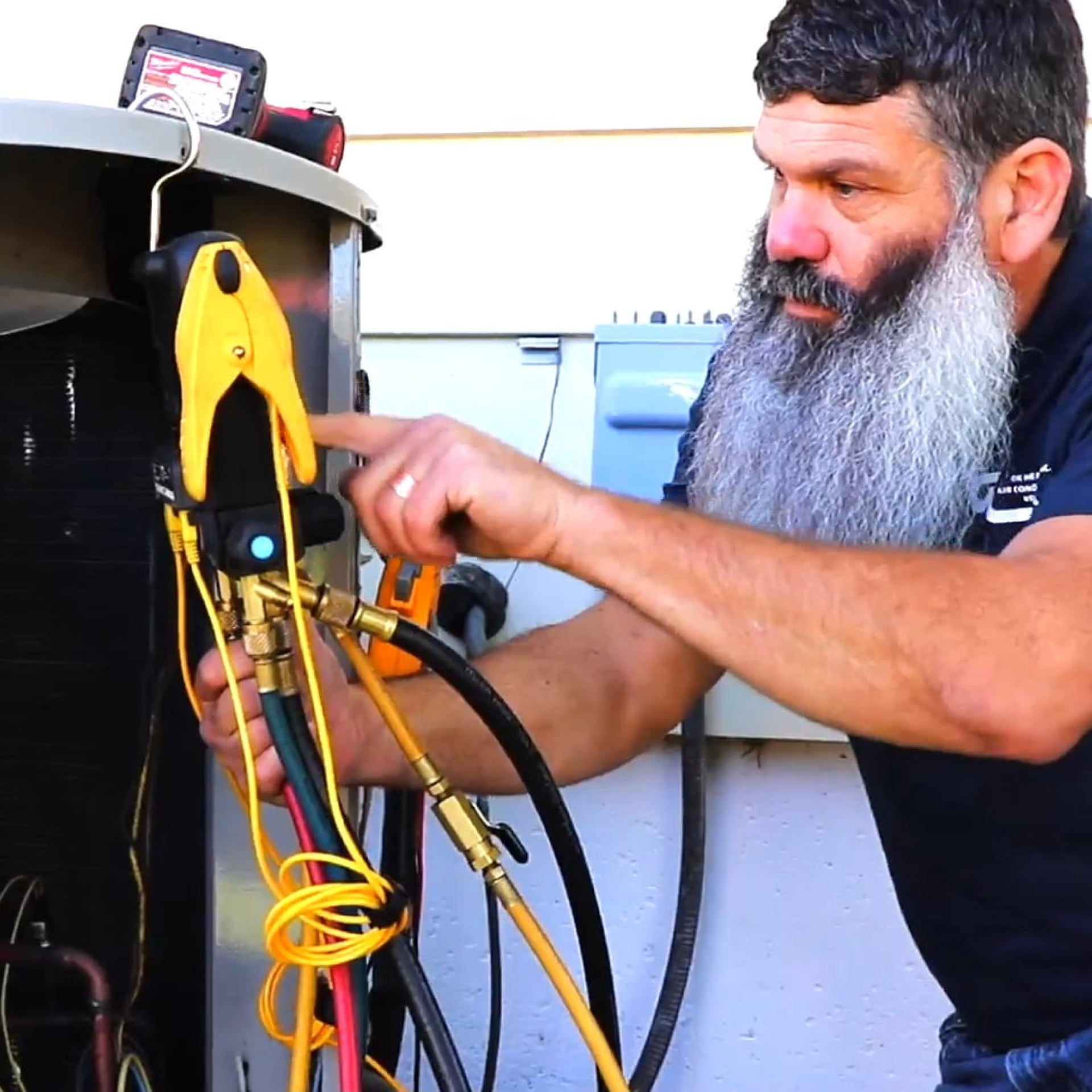 Josh Maier of OK Heating and Air Conditioning working on air conditioning unit